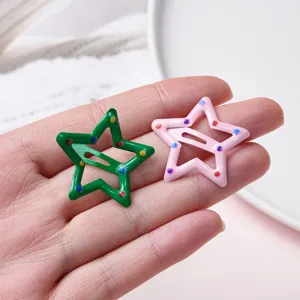 Close-up detail of cute star metal BB hair clips in green and pink with colorful dots.