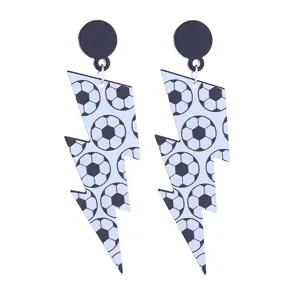 Gros plan détaillé de boucles d'oreilles en acrylique à motif de ballon de football.
