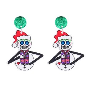 Close-up details of Christmas skeleton snowman acrylic earrings with green glitter studs.