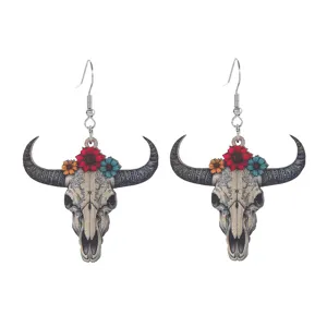 Detailansicht von hölzernen Stierschädel-Ohrringen mit Blumendekor im Vintage Western Stil.
