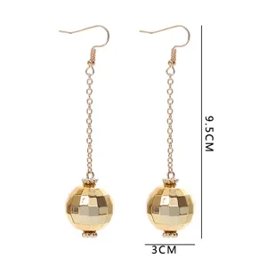 Retro gold disco ball dangle earrings detail, featuring long chain and faceted spherical charm.