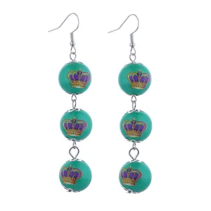 Lange carnaval kralen oorknopjes met groene ballen en paars gouden kroonprint voor feest.