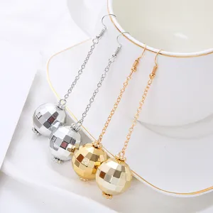 Close-up detail of vintage disco ball long chain earrings in silver and gold, ear hook design.