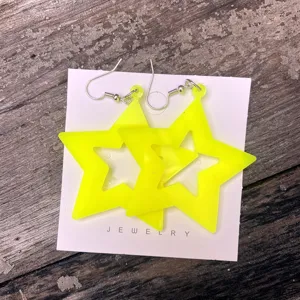 Neon gele acryl ster holle oorbellen detailweergave, perfect voor jaren 80 feest.
