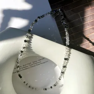 Detailaufnahme der Perlen-Choker-Halskette mit funkelnden Kristallen und schwarzen Perlen.