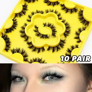 Close-up detail shot of fluffy curled false eyelashes arranged neatly in a yellow tray.