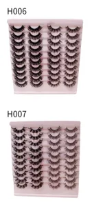 Detailansicht von russischen Locken-Falschwimpern im H006 und H007 Stil auf rosa Tabletts.