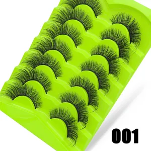 Detailansicht von 7 Paaren flauschigen falschen Wimpern auf grüne Schale, dichter Volumen-Stil.