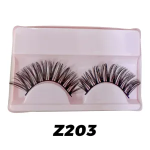Detailansicht von dichten und geschwungenen künstlichen Wimpern in einer rosa Schale.