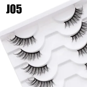 Detaillierte Nahaufnahme mehrschichtiger dichter, geschwungener künstlicher Wimpern auf Ablage.