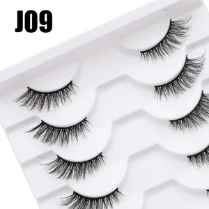 Detaillierte Detailansicht mehrschichtiger voluminöser künstlicher Wimpern auf weissem Tablett