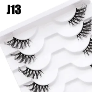 Detailansicht mehrschichtiger dichter halber künstlicher Wimpern auf weißer Schale.