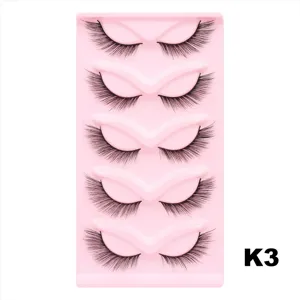 Nahaufnahme Detail von 5 Paar künstlichen Wimpern, dicker Cat-Eye-Stil auf pinker Schale.