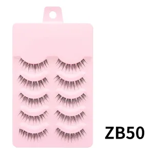 Detailansicht von 5 Paaren natuerlichen kuenstlichen Wimpern auf rosa Tablett Alltag Make-up