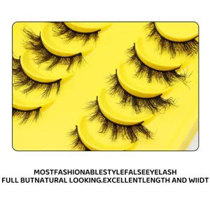 Detaillierte Nahaufnahme von dichten künstlichen Wimpern auf gelbem Tablett für Augen-Make-up.