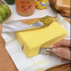 Stainless steel butter knife with wooden handle detail view for smooth spreading butter.