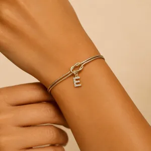 Detailed view of 18K gold snake chain bracelet featuring a sparkling rhinestone letter E pendant.