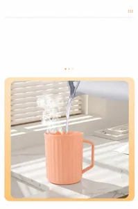 Pratico bicchiere da bagno in plastica con manico e strisce verticali per denti.