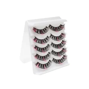 Detaillierte Nahaufnahme farbiger künstlicher Wimpern mit schwarz-rosa Locken auf einer weißen Schale.