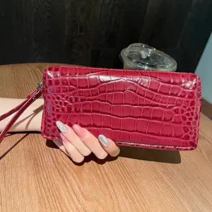 Portafoglio lungo rosso con stampa coccodrillo pochette con cinturino da polso.