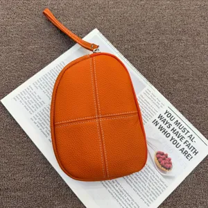 Orange genuine leather coin purse wristlet bag detail, premium pebble leather with white stitching.