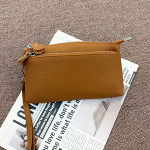 Detailed view of the brown genuine leather multi-zipper clutch bag with practical wrist strap.