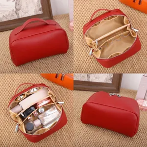 Red leather cosmetic bag with multi-layer interior compartments, ideal for travel makeup storage.