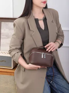Brown leather cosmetic bag detail view, compact travel makeup pouch with secure zipper.