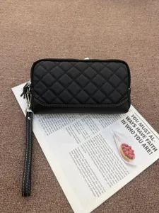 Black quilted leather wallet detail, featuring durable zip closure and convenient wrist strap.
