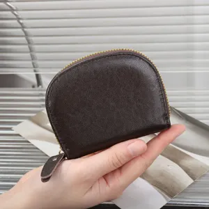 Close-up detail of the brown leather mini coin purse zipper pull and texture craftsmanship.