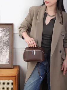 Premium brown leather cosmetic bag with top handle and double zippers for women daily use.
