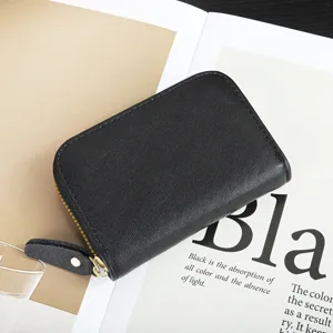 Monedero tarjetero mini de piel negra con cremallera vista en detalle, diseño muy compacto.