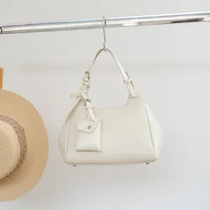Detailed view of the elegant genuine leather shoulder bag in off-white with mini pouch charm.