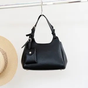 Black genuine tumbled cowhide leather crossbody shoulder handbag with small pouch pendant detail.