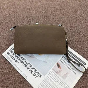 Genuine leather wristlet clutch bag detail shot, compact coin purse with zipper closure.