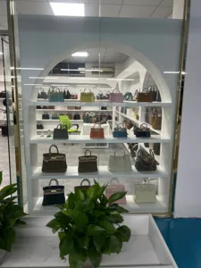 Showroomdisplay met verschillende klassieke luxe handtassen van leer met metalen sluitingen.