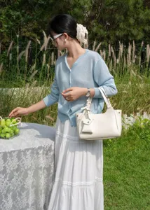 Elegant genuine leather shoulder bag for women with chic mini pouch pendant detail.