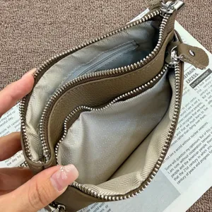 Genuine leather multi-zipper clutch bag interior detail, top layer cowhide purse storage.