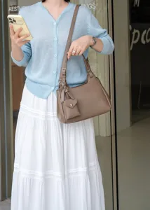 Close-up detail of the premium leather hobo shoulder bag with cute hanging pouch accessory.