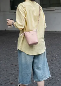 Pink leather crossbody phone bag detail view, casual on-body wear with a thin strap.