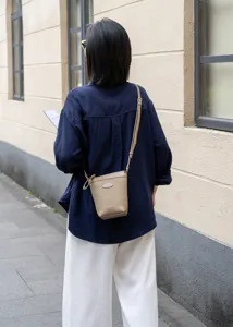 Minimalist genuine leather crossbody phone bag detail, soft top layer cowhide, daily commute.