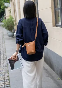 Classic brown leather bucket bag for women, stylish crossbody shoulder bag for daily commute.