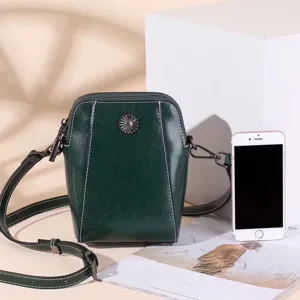 Green oil wax leather crossbody phone bag detail showing fine stitching and metal flower decor.
