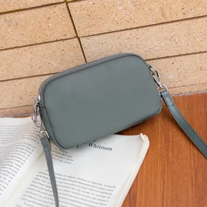 Grey genuine leather crossbody shoulder bag with double zippers and slim strap for women.