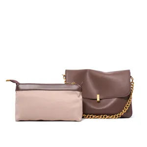 Detailed view of women brown leather shoulder bag with gold chain and matching accessory pouch.