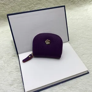 Detail view of a purple genuine leather mini coin purse with zipper and cute flower emblem.