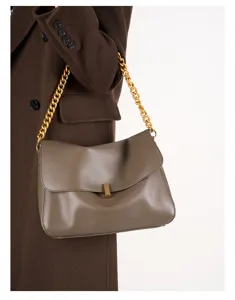Brown leather shoulder bag detail, chunky gold chain strap and metal lock clasp for women.