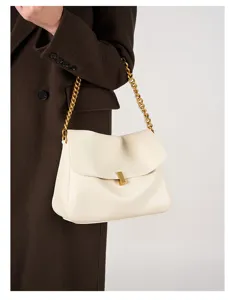 Detailansicht der cremeweißen Leder-Umhängetasche mit goldener Kette und edlem Metallverschluss.