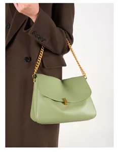 Detail der Ledertasche, eleganter Goldkettengurt, Metallschloss, glatte Textur, schickes Design.