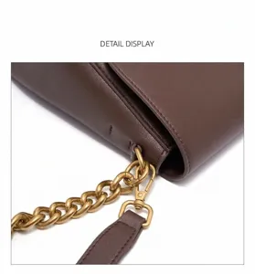 Detailansicht der Ledertasche mit Metallkettengurt und brauner Ledertextur.